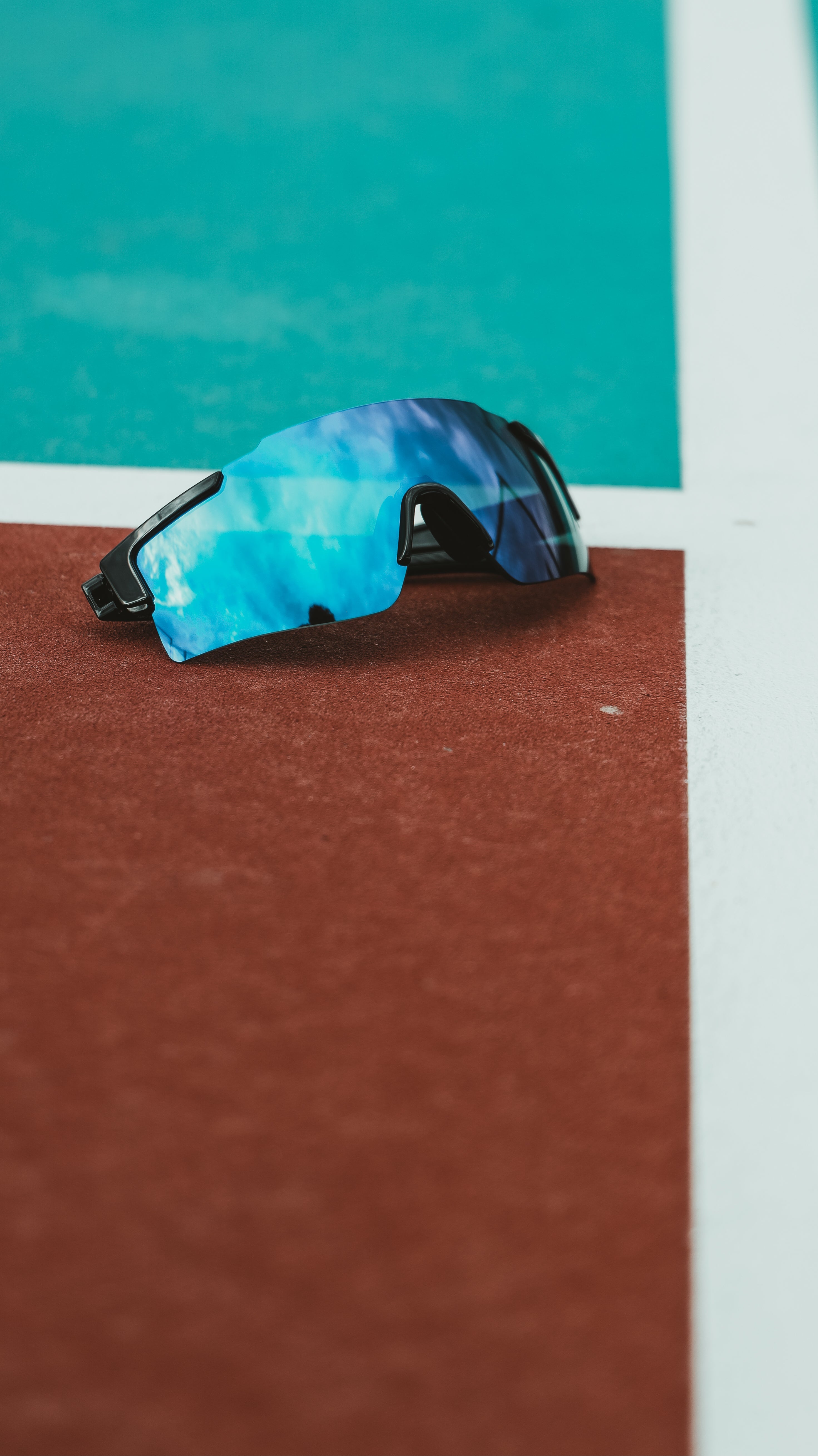 Blue and black pickleball goggles on a pickleball court. Pickleball glasses